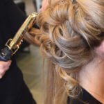 Blond woman getting hair curled